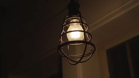 Slow motion handheld shot of old rustic front porch light during night Stock Footage 210220275