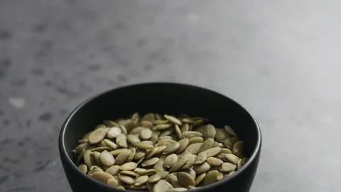 Slow motion handheld shot of pumpkin in black bowl on terrazzo countertop Stock Footage 348548579