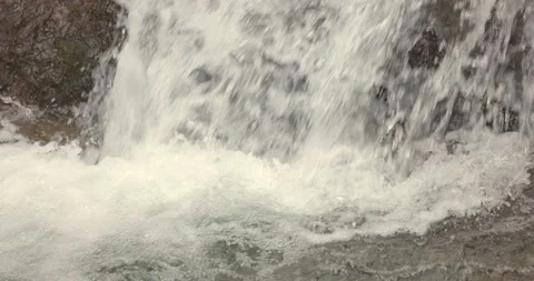 Slow Motion Handheld Shot of Waterfall Splashing Over Rocks Stock Footage 302961593