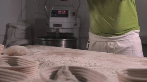 Slow motion of hands of baker chef applying flour on dough. Making bread using Stock Footage 156333260