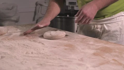 Slow motion of hands of baker chef applying flour on dough. Making bread using Stock Footage 156333288