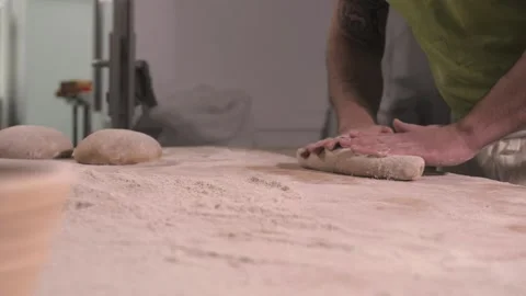 Slow motion of hands of baker chef applying flour on dough. Making bread using Stock Footage 156333309
