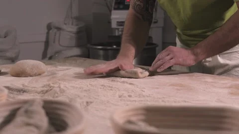 Slow motion of hands of baker chef applying flour on dough. Making bread using Stock Footage 156333340