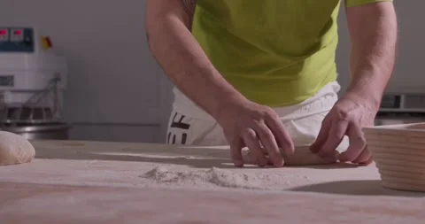 Slow motion of hands of baker chef applying flour on dough. Making bread using Stock Footage 156334429