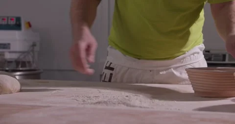 Slow motion of hands of baker chef applying flour on dough. Making bread using Stock Footage 156334455