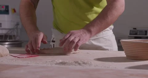 Slow motion of hands of baker chef applying flour on dough. Making bread using Stock Footage 156334494