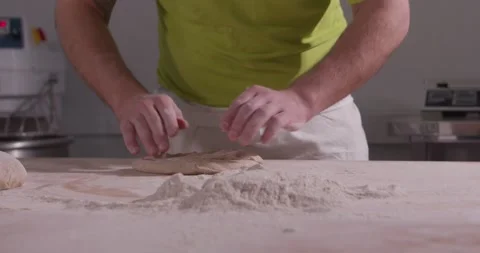 Slow motion of hands of baker chef applying flour on dough. Making bread using Video stock 156334521