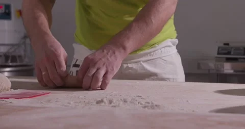 Slow motion of hands of baker chef applying flour on dough. Making bread using Stock Footage 156334617