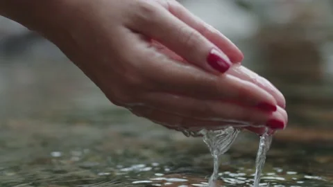 Slow motion hands grabbing and lifting clear water from a river Stockbeeldmateriaal 151691689