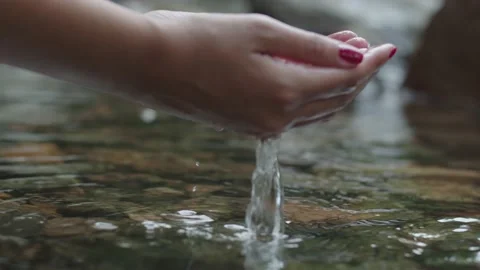 Slow motion hands grabbing and lifting clear water from a river Stockbeeldmateriaal 151692000
