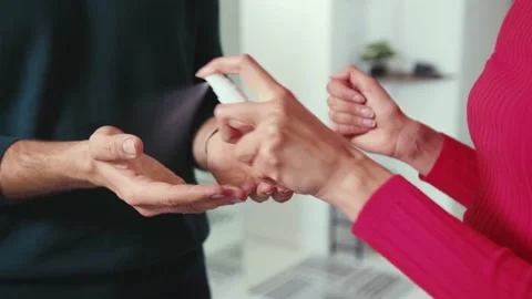 Slow motion hands man and woman hands spraying antiseptic into the house couple Stock Footage 132539405