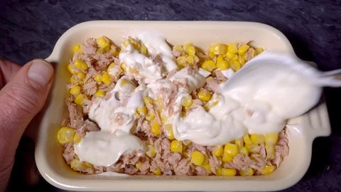 Slow motion –  Hands mixing mayonnaise with sweetcorn &amp; chopped tuna in dish. Stock-Footage 101681978