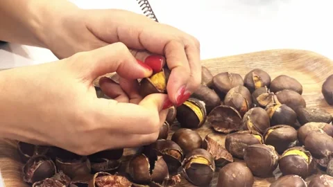 Slow motion, hands peeling a small chestnut Stock Footage 262646195