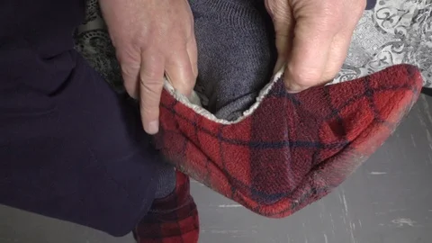 Slow motion: Hands pulling on a stretchy slipper. Stock Footage 97642933