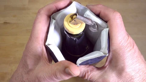 Slow motion: Hands pushing a cold wine cooler jacket / sleeve around a bottle. Video stock 97573273