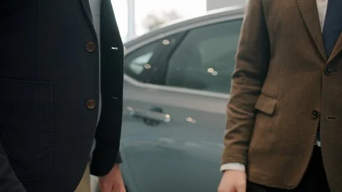Slow motion of handshake, male customer buying car in showroom taking keys Stock Footage