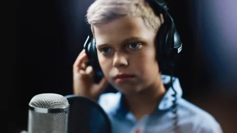 Slow motion handsome singer boy writing song in the studio male music mic Stock Footage 98216692