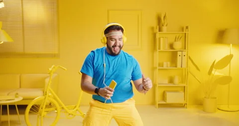 Slow motion handsome young man listening to music with headphones while holding Stock Footage 165866296