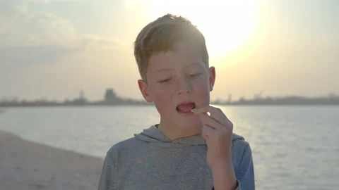 Slow motion of happy boy with crackers on the coast at sunset. Family Stock Footage 135145483
