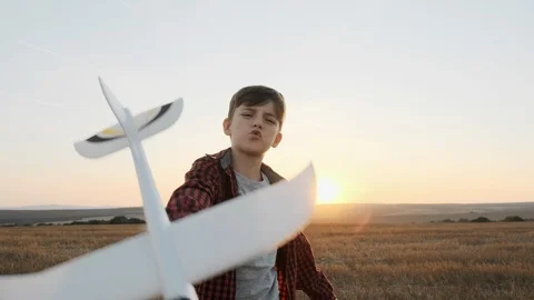 Slow motion of a happy boy on a summer meadow holding a plane in his hand Stock Footage 118433237