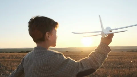 Slow motion of a happy boy on a summer meadow holding a plane in hand Stock Footage 118433795