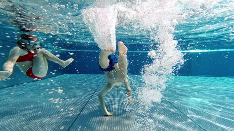 Slow motion of happy children having fun under water in swimming pool during Stock Footage 201352409
