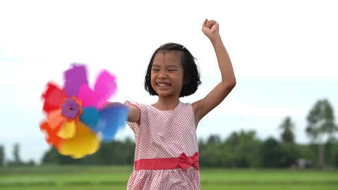 Slow motion happy children playing colorful pinwheel in meadow on sky background Stock-Footage 158490647