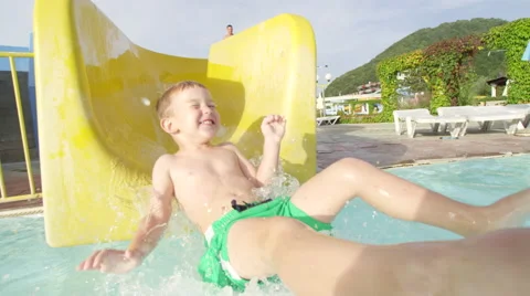 SLOW MOTION: Happy kid smiling sliding down the toboggan in aquapark Stock Footage 58839355