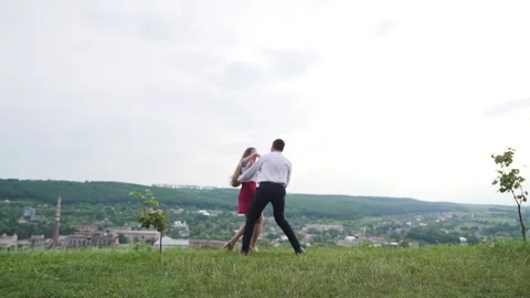 Slow motion. Happy man and woman having fun, turning around. Top on the hill Stock Footage 221018182