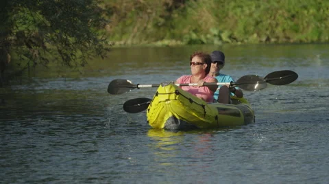 SLOW MOTION: Happy smiling couple in boat oaring on river Stock Footage 59145893