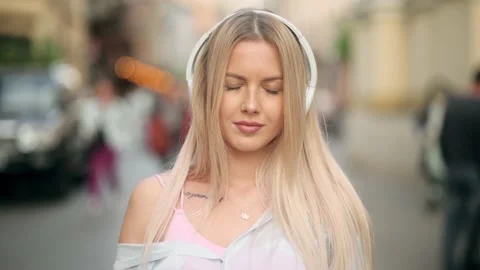 Slow motion of happy young blonde woman in wireless headphones dancing singing Stock Footage 197007974