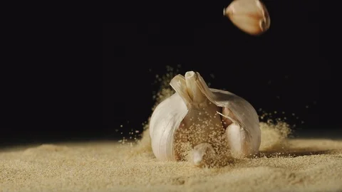 SLOW MOTION: Head garlic falling in powder which spreads around Stock Footage 107501323