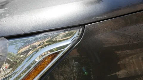 Slow motion headlights washing with automatic pressure washer close-up Stock Footage 96737632