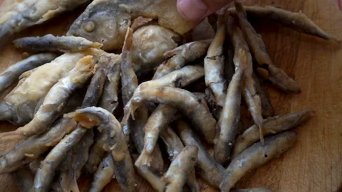 Slow motion heap of fried fish lying on a wooden table. Stock Footage 113354948