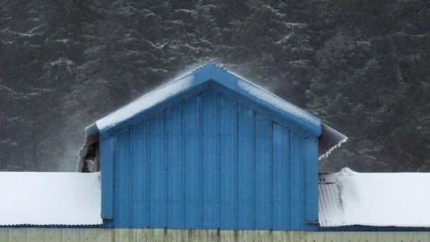 Slow motion of heavy snow falling down on top of small building in Cordova Stock Footage 129109400