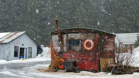 Slow motion of heavy snow falling down on old sailor building in thick forest Stock Footage 129111447