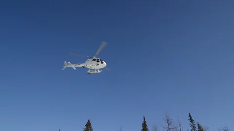 Slow motion of helicopter flying above ground with sky in background, Alaska Stock Footage 129127678