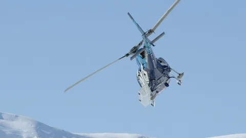 Slow motion of helicopter flying above rocky mountains covered in snow, Alaska Stock Footage 129127963