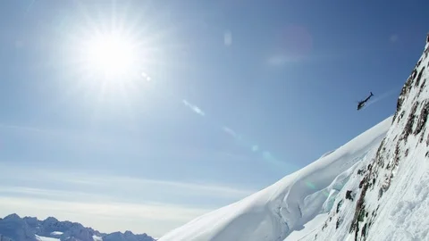 Slow motion of helicopter flying down from snow covered mountains in Alaska Stock Footage 129110844