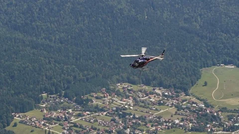 Slow-motion helicopter flying over a mountain carrying construction materials Video stock 96534649
