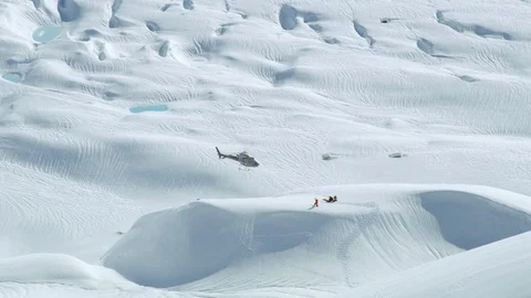 Slow motion of helicopter rescuing people from heavy snow covered area Stock Footage 129110539