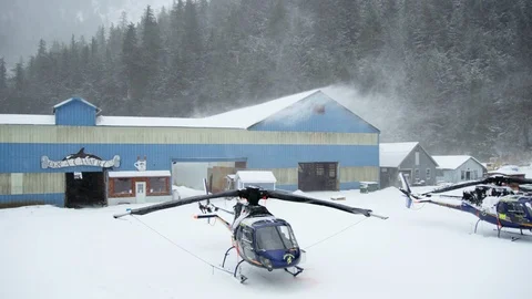 Slow motion of helicopter standing in ski resort during heavy blizzard Stock Footage 129109476