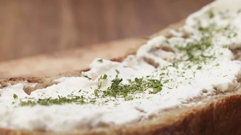 Slow motion of herbs falling on rustic bread with ricotta cheese Stock Footage 74764357