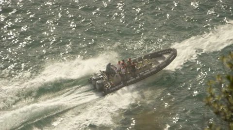 A slow motion high angle shot of a Speed Boat on the ocean with passengers. Vídeo Stock 57979123
