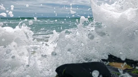 Slow motion high speed waves crashing into camera, and moss covered rocks on Stock Footage 71315452