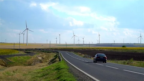 Slow motion on highway. Wind farm and cultivated land background Stock Footage 77682376