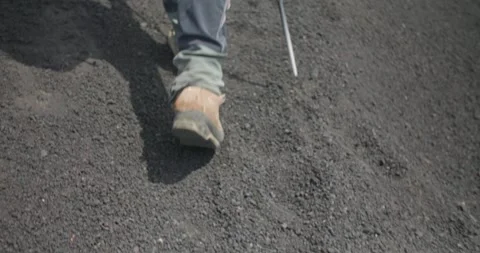 Slow motion of a hiker walking on dark volcanic terrain, Etna Volcano, 4k Video stock 332715833