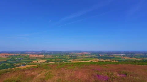 Slow motion hilltop field overview under blue sky with clouds Stock Footage 340441673