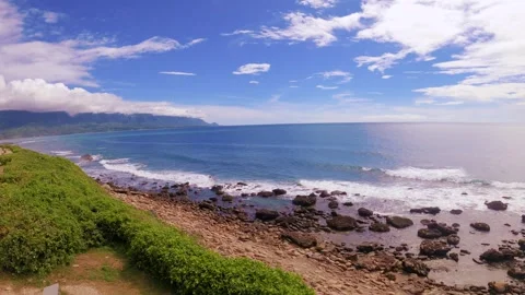 Slow motion horizontal still view look out to blue ocean horizon at rocky sandy  Stock Footage 313345210