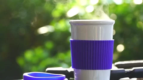 Slow motion. Hot ceramic white coffee cup with smoke placed outside the car Stockbeeldmateriaal 253249461